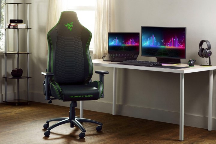 A Razer Iskur X gaming chair sets by a video game setup.