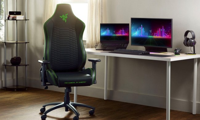 A Razer Iskur X gaming chair sets by a video game setup.