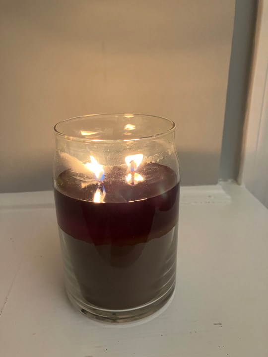 A scented candle burning on a ledge