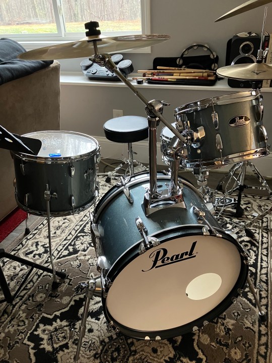 A drum set placed on a rug.