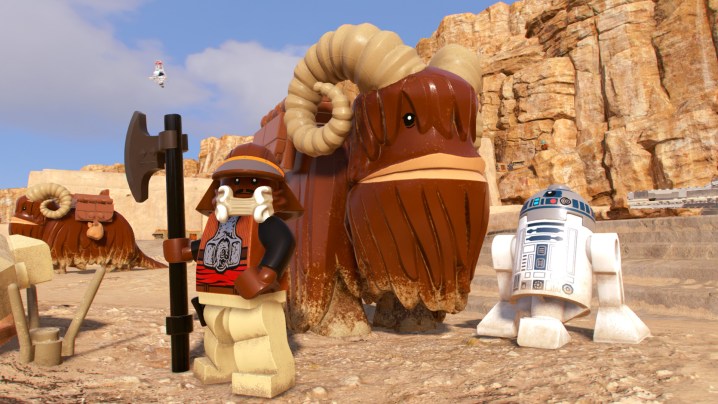 Lando and R2D2 stand by a Bantha in Lego Star Wars: The Skywalker Saga.