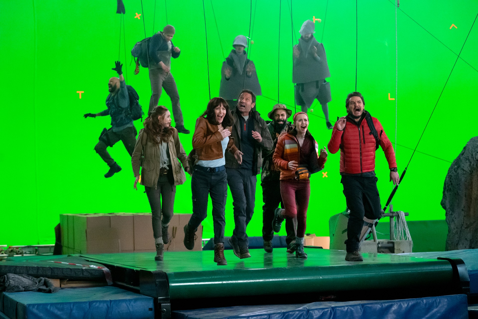 O elenco de The Bubble finge correr contra um fundo de tela verde em uma cena do filme.