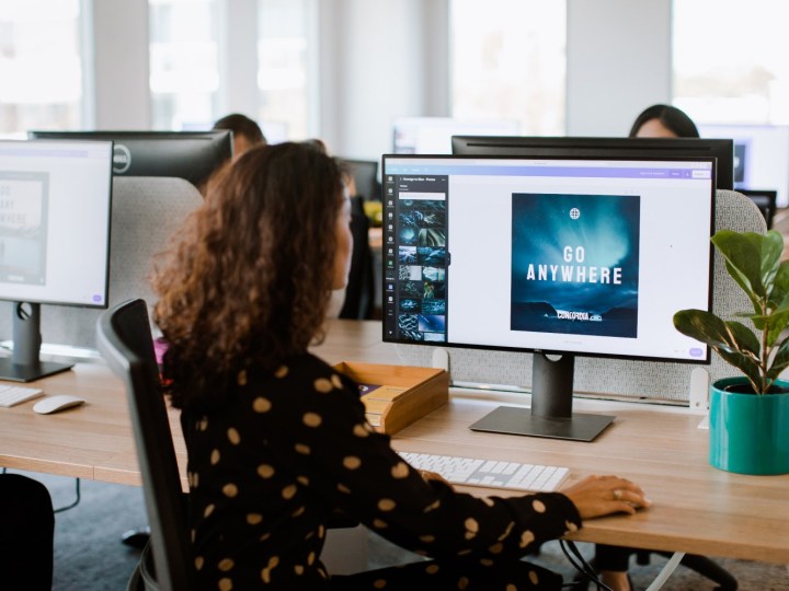 Woman using Canva Pro to create at her work desk.
