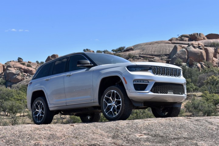 The 2022 Jeep Grand Cherokee 4xe plug-in hybrid perched on a rock.