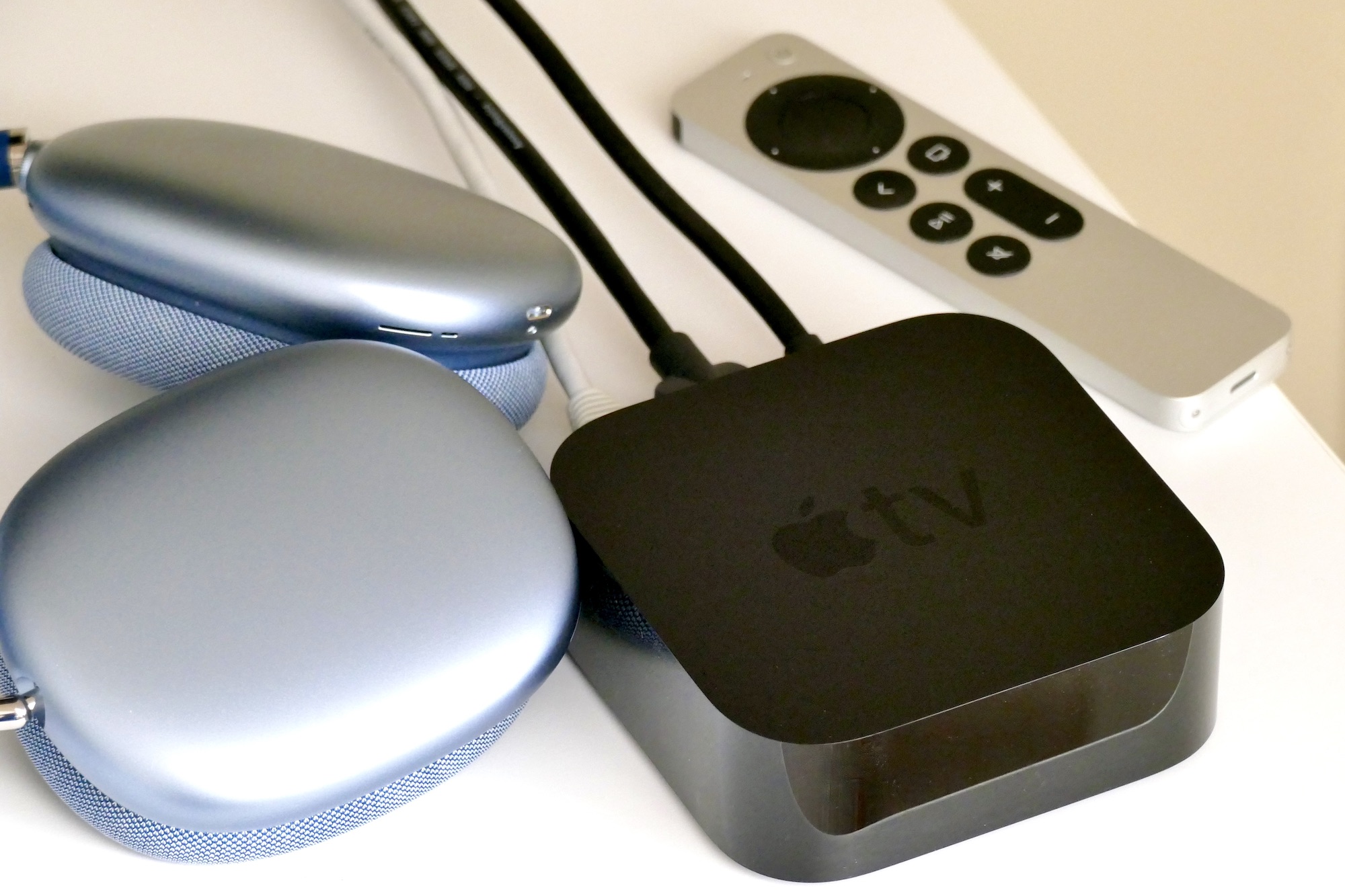 The AirPods Max and Apple TV 4K with remote on a table.