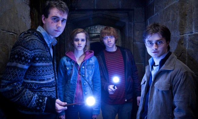 Neville, Hermione, Ron, and Harry inside a dark tunnel in HP and the Deathly Hallows Part 2.