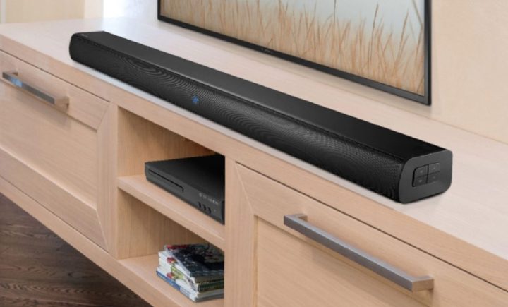 The Insignia NS-HTSB22 2.0-Channel Soundbar on a wooden home theater table.