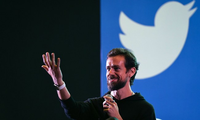Jack Dorsey sits in front of a Twitter logo.