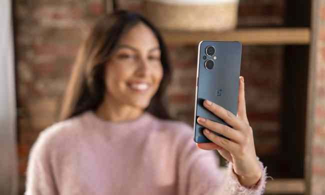 Woman holding up OnePlus Nord N20 to take a selfie.