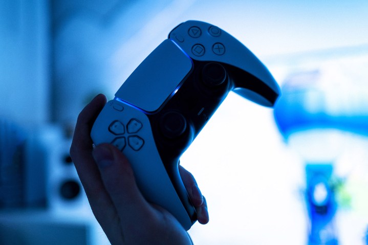 A person holds up a PS5 controller.