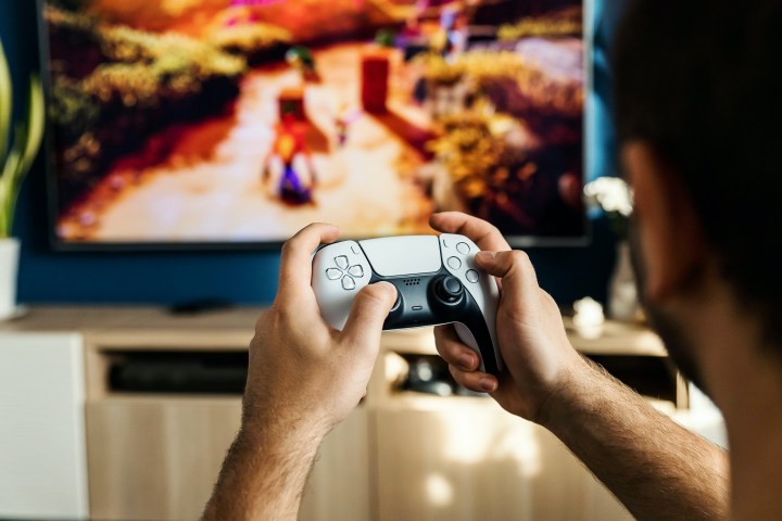A person plays Crash Bandicoot using a PS5 DualSense controller.