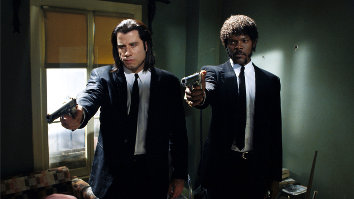 John Travolta y Sam Jackson como Vincent Vega y Jules Winnfield apuntando armas en la misma dirección en la película Pulp Fiction.