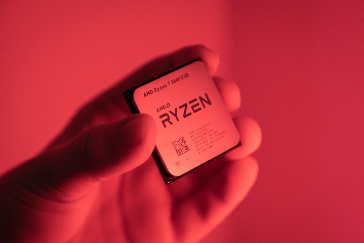 Someone holding the Ryzen 7 5800X3D in a red light.