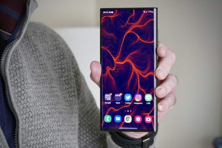 Hombre sosteniendo un Samsung Galaxy S22 Ultra mostrando su gran pantalla AMOLED.