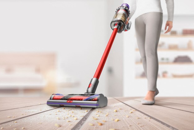 Girl vacuuming floor with Dyson V11 Outsize Total Elegant Cordless Vacuum.