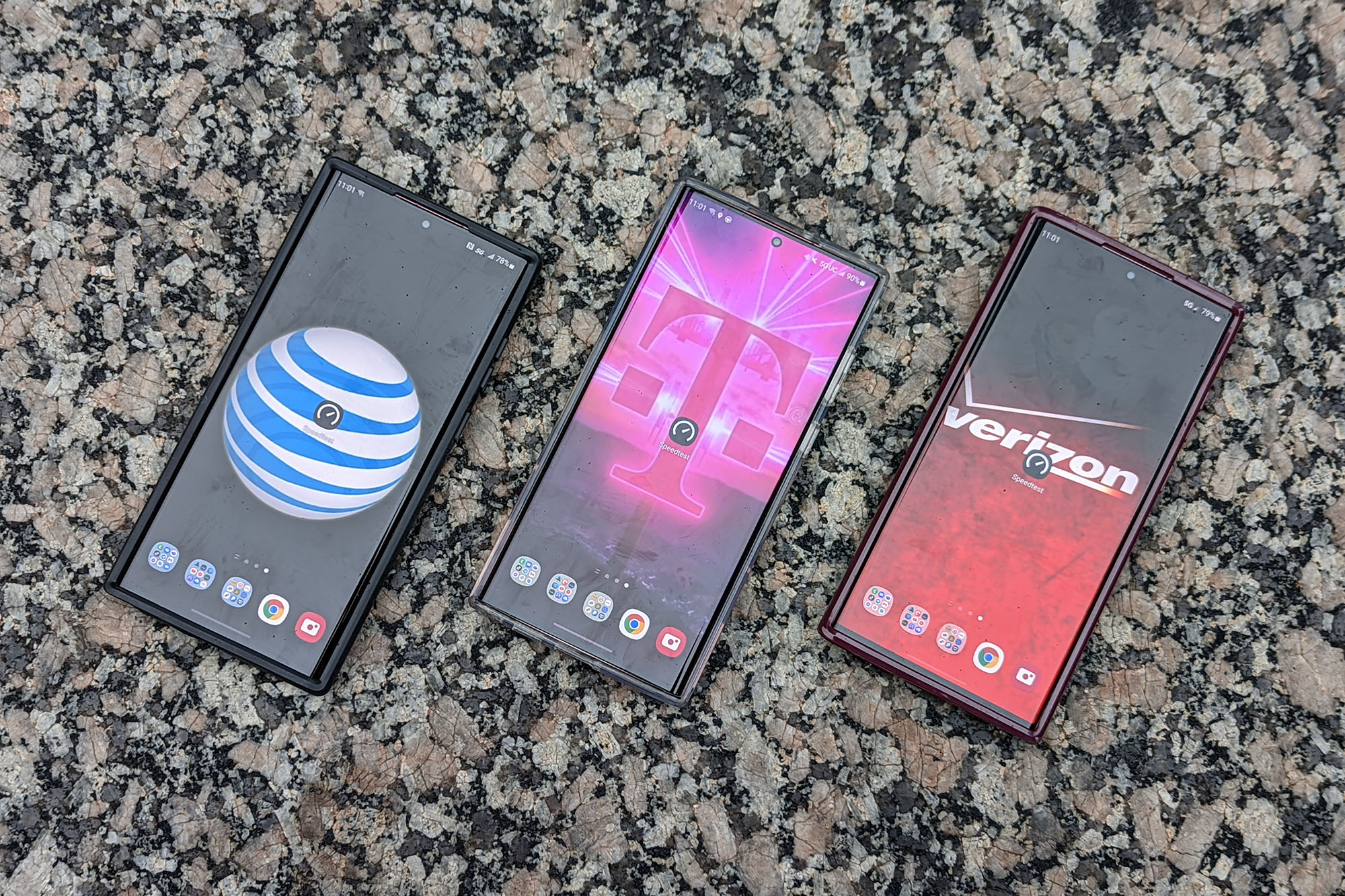 Phones from three carriers rest on a marble slab.