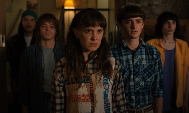 Eleven, Will, Mike, and Jonathan standing and staring in a still from Stranger Things Season 4.