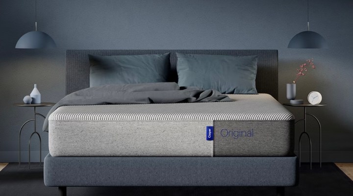 Il materasso Casper Original si trova su un giroletto in una camera da letto blu.