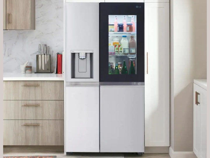 Un réfrigérateur côte à côte LG dans une cuisine avec des armoires marron clair.