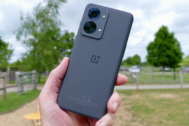 The OnePlus Nord 2T held in a man's hand seen from the back.