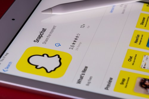 The Snapchat app store listing on a mobile device with a stylus resting on it.