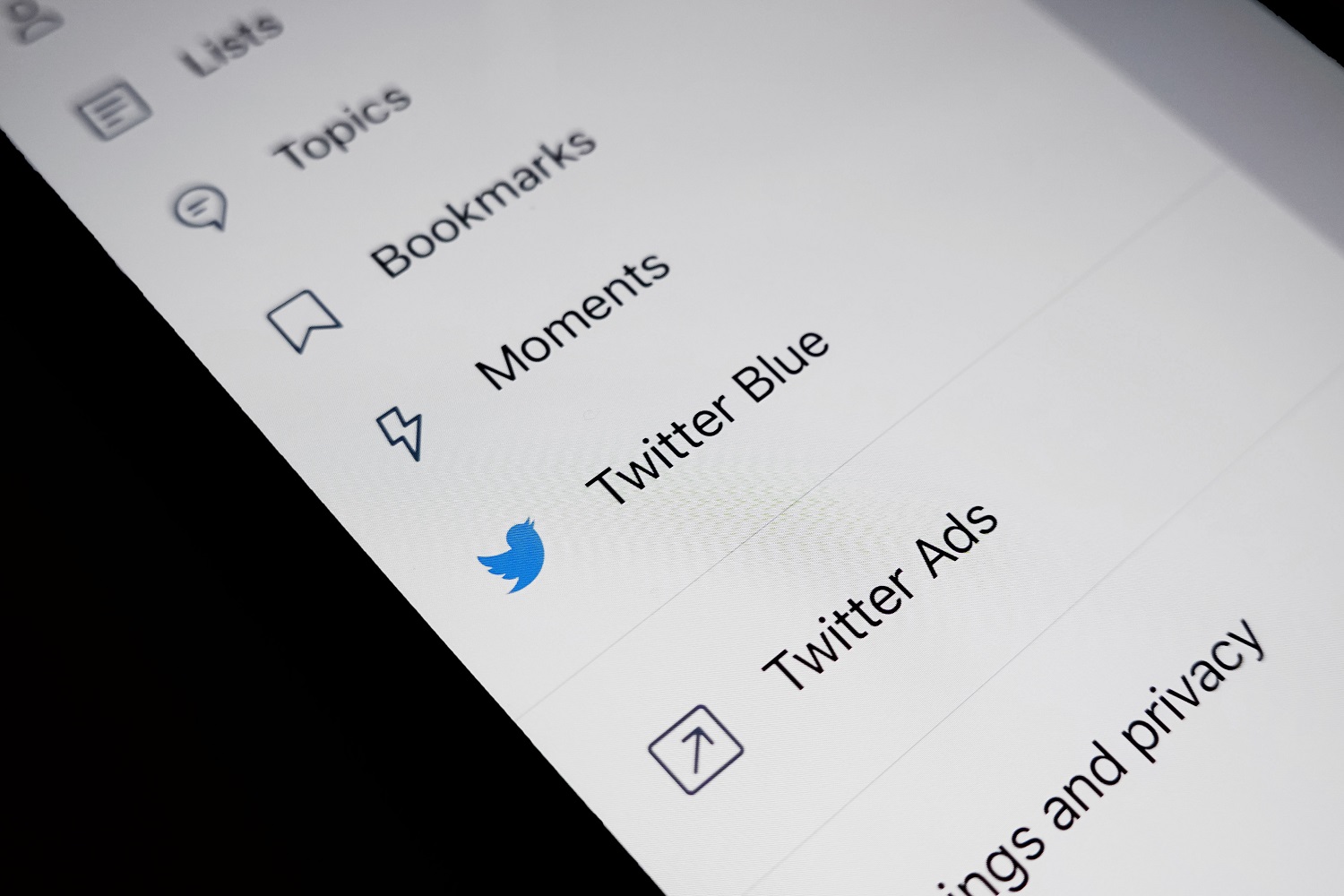 Twitter Opción de menú azul sobre un fondo de pantalla blanco que está sobre un fondo negro.