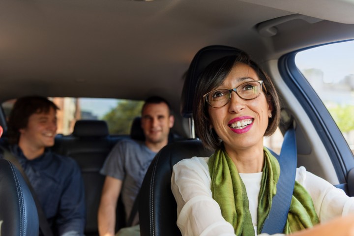 An Uber driver conversing with her passengers.