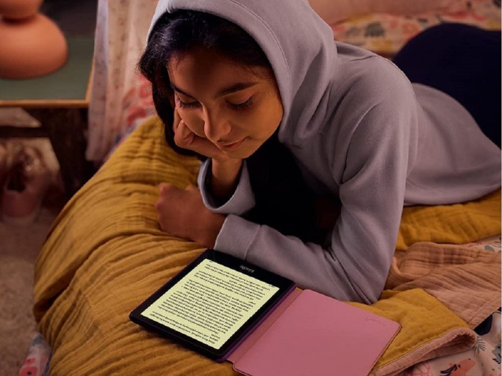 A girl is reading an e-book on Amazon Kindle Paperwhite Kids.