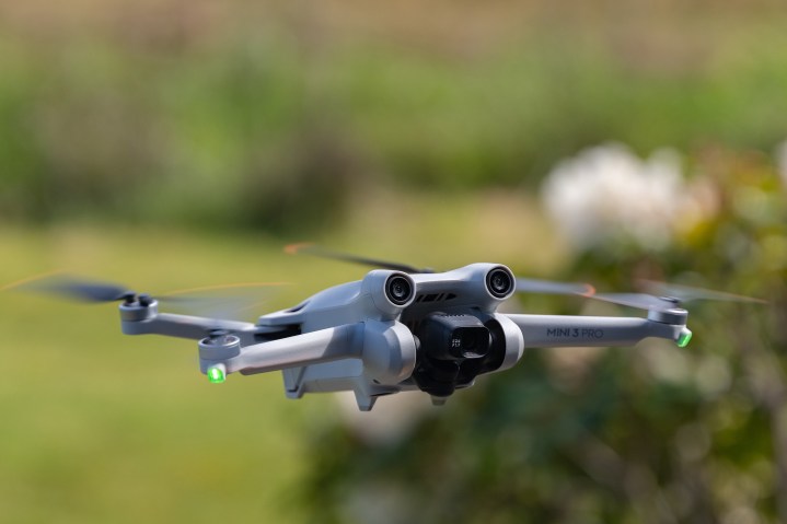 The DJI Mini 3 Pro in flight with spring flowers in the background.