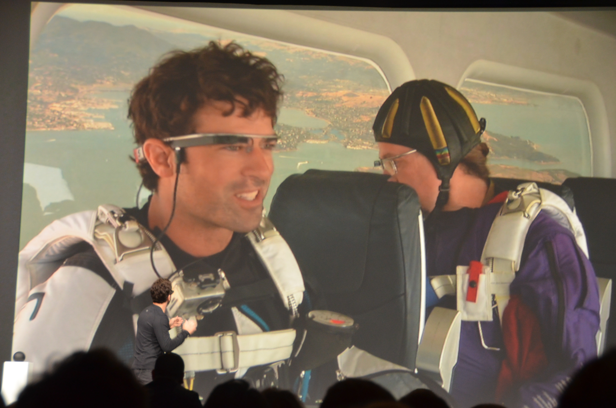 Skydivers wearing Google Glass on screen at Google I/O 2012.