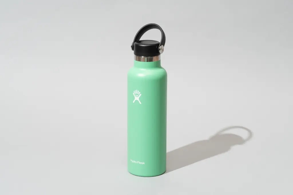 Uma garrafa de água Hydro Flash verde menta sobre um fundo cinza.