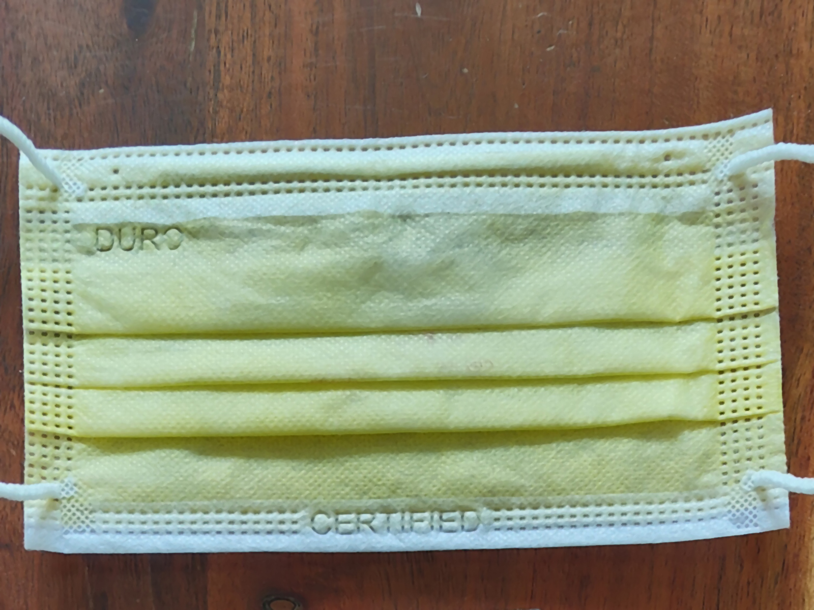 A polyester-based yellow surgical mask photographed with the Realme GT 2 Pro's primary 50MP camera.