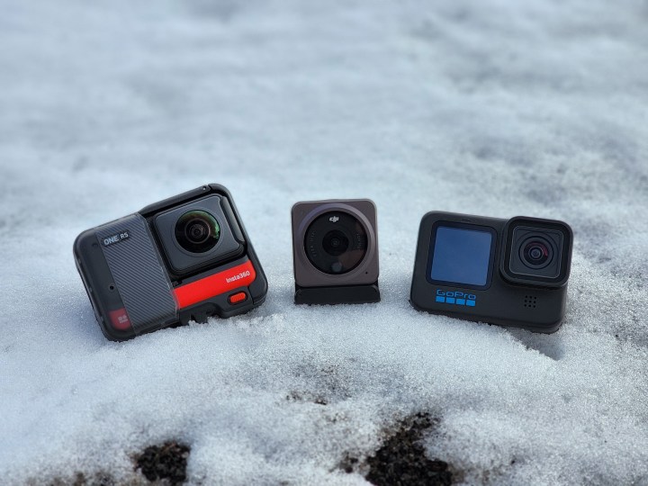 The Insta360 One RS with the 360 lens mod, DJI Action 2, and GoPro Hero 10 Black in a snow bank.