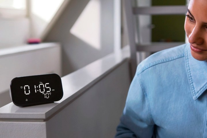 A woman checks the time on the Lenovo Smart Clock Essential.