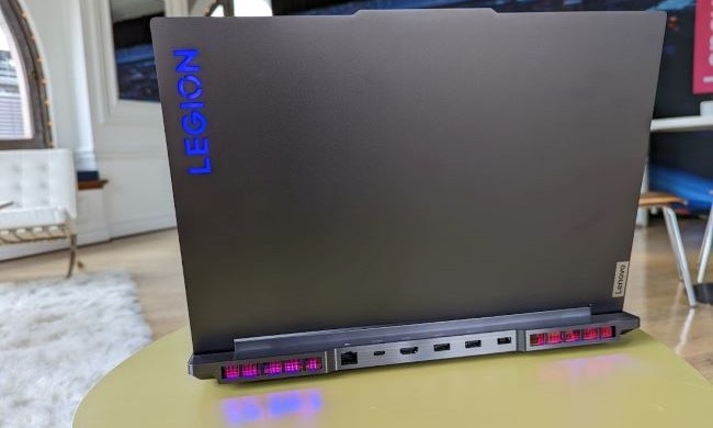 Lenovo Legion 7 laptop shot from the back with logo showing and RGB lighting showing on the table.