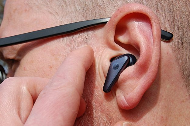 Wireless earbud in ear about to be tapped.