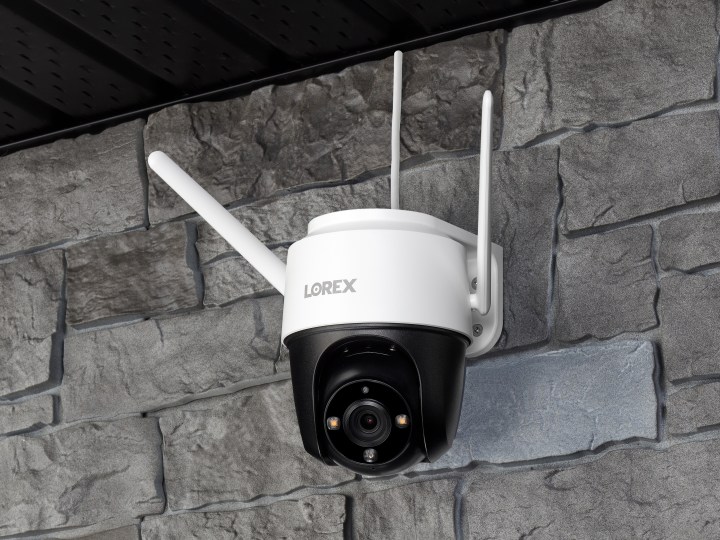 Lorex 2K Pan-Tilt Wi-Fi Outdoor Security Camera mounted on stone wall.