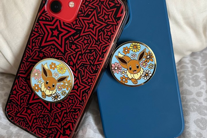 Two iPhone 12s leaning on one another with matching Pokemon PopSockets.