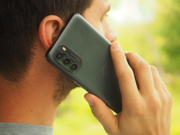 Una persona che tiene uno smartphone Moto G 5G vicino all'orecchio