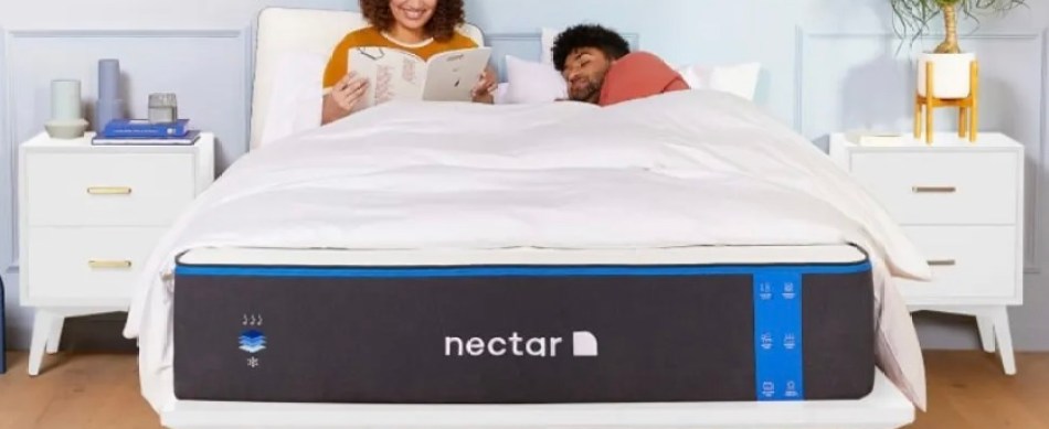 A couple rest on a Nectar Memory Foam Mattress in a bedroom.