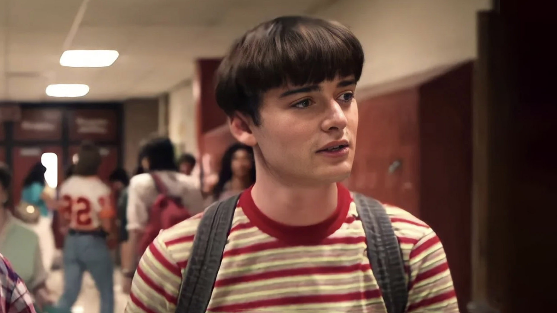 Will Byers caminha pelo corredor de uma escola na 4ª temporada de Stranger Things.