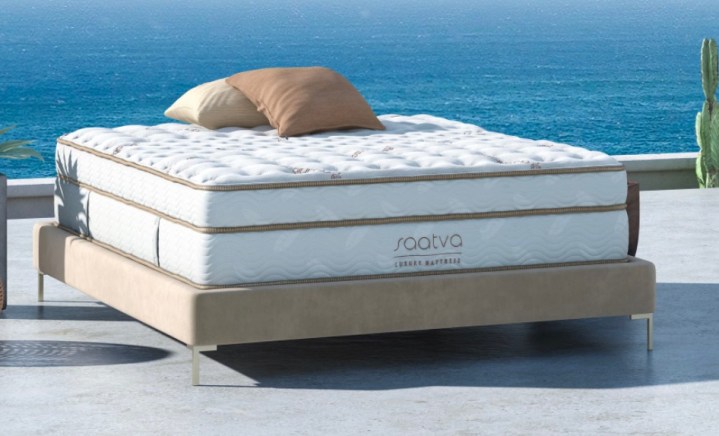 This is an image of a Saatva classic mattress on a stone floor by the sea.