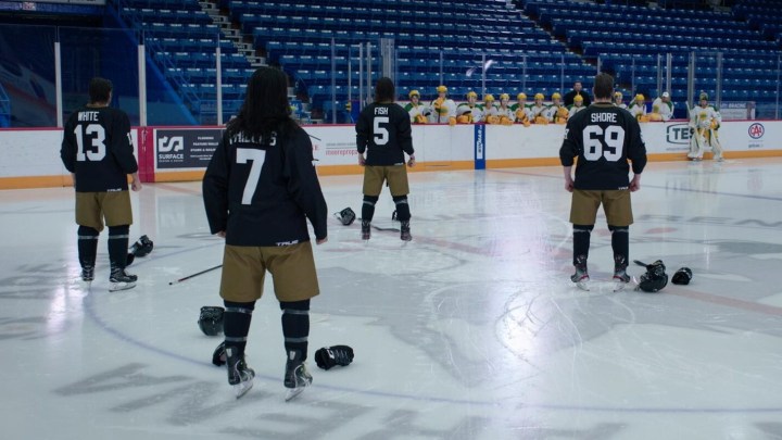 The Sudbury Bulldogs stare down a rival team on the ice in a scene from Shoresy.