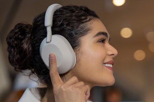 Woman wearing Sony WH-1000XM5 headphones.