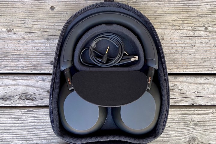 索尼 WH-1000XM5 无线耳机装在旅行箱中，配件可见。