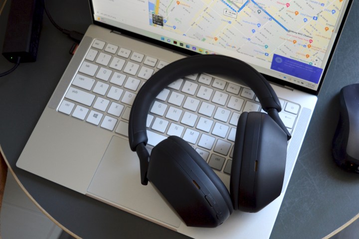 Sony WH-1000XM5 wireless headphones sitting on a laptop keyboard.