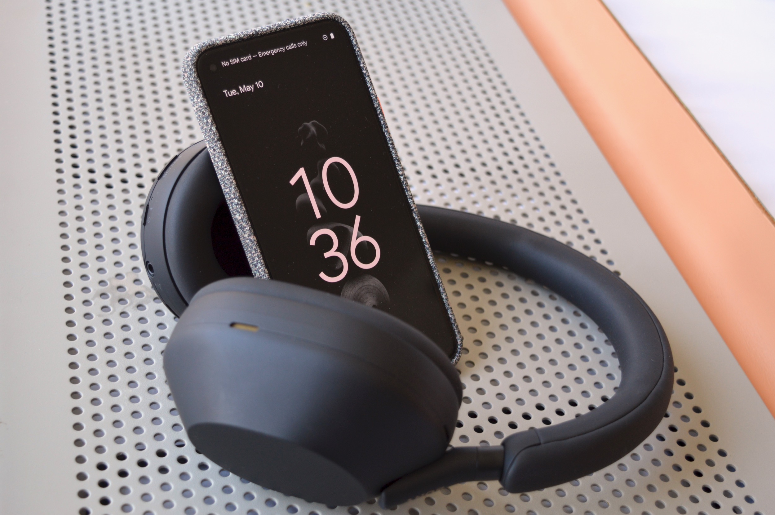 Fones de ouvido sem fio Sony WH-1000XM5 vistos com um smartphone.