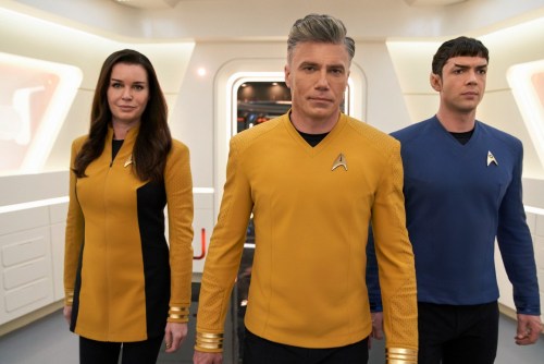 Rebecca Romijn, Anson Mount, and Ethan Peck walk in the hallway of the USS Enterprise in a scene from Star Trek: Strange New Worlds.