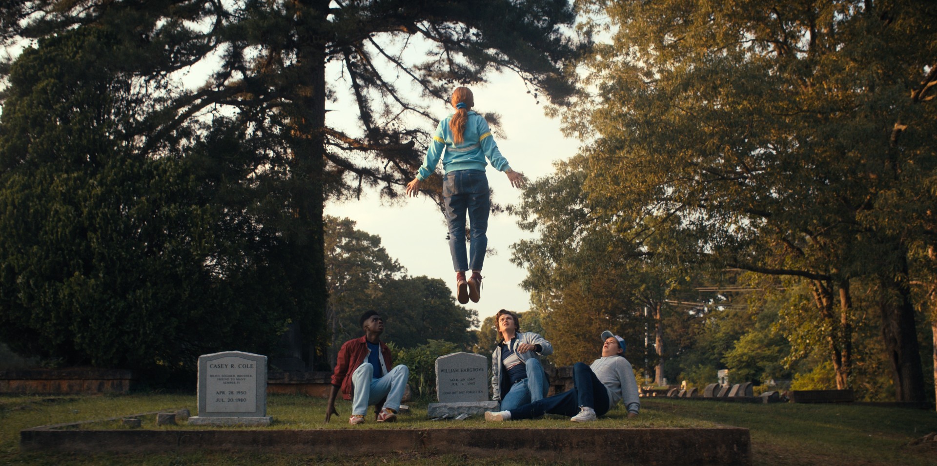A personagem de Sadie Sink levita sobre um grupo de personagens em uma cena de Stranger Things 4.