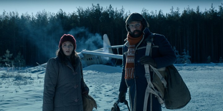 Winona Ryder e Brett Gelman si trovano di fronte a un aereo precipitato nella neve in una scena di Stranger Things 4.